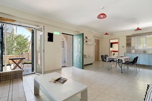 A modern interior with a dining area, a kitchen, and a balcony.
