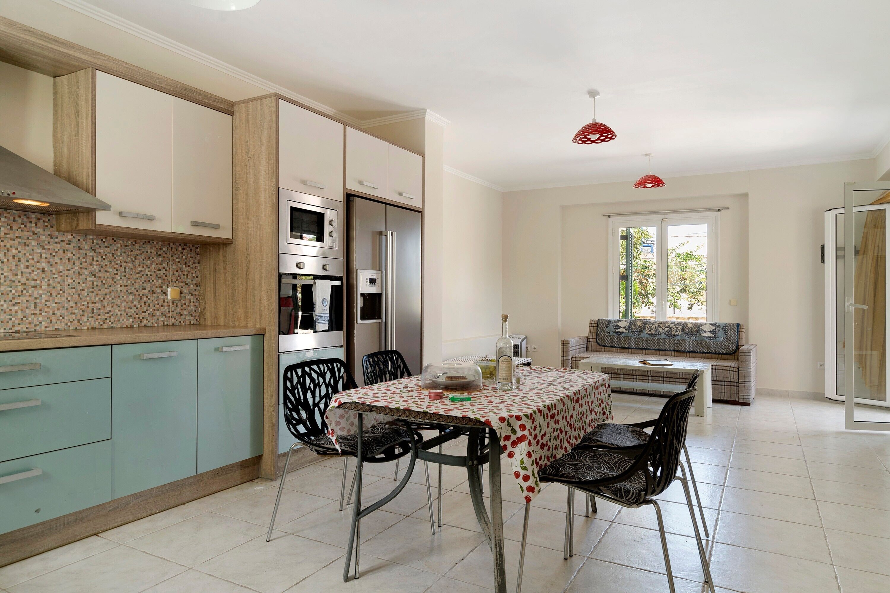 A modern kitchen with a dining area, including a table with chairs and a bench.