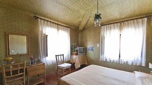Ein Hotelzimmer mit Bett, Schreibtisch, Stuhl und Fernseher.