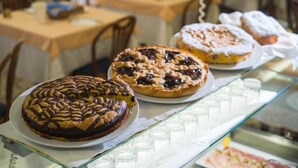 A bakery display with various pastries and a glass case with cups.