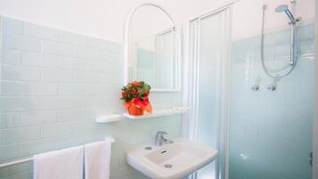 Driepersoonskamer, balkon | Badkamer | Een douche, een haardroger, handdoeken, toiletpapier