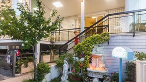A hotel entrance with a staircase, a statue, and a signboard.