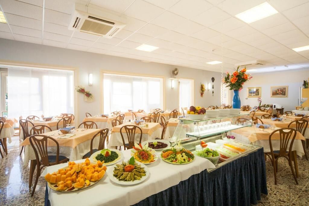 A buffet setup with multiple food stations, including a cheese platter, salads, and a fruit display.
