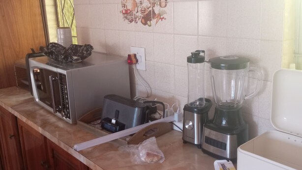 A kitchen with a microwave, toaster, blender, and a coffee maker on the counter. - Luxurious 4-bedroom House Rental With Pool Access in Ngaka Modiri Molema (Mahikeng)