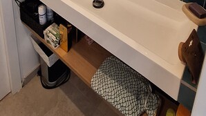 Ett badrum med ett vitt handfat, en spegel och blå kakelplattor på väggarna.