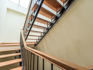 A staircase with wooden steps and black metal railings, leading to an upper floor. - Arrifes Porto Santo by Interhome (Porto Santo)