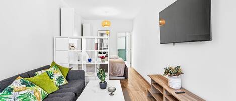 A modern living room with a sofa, coffee table, and TV.