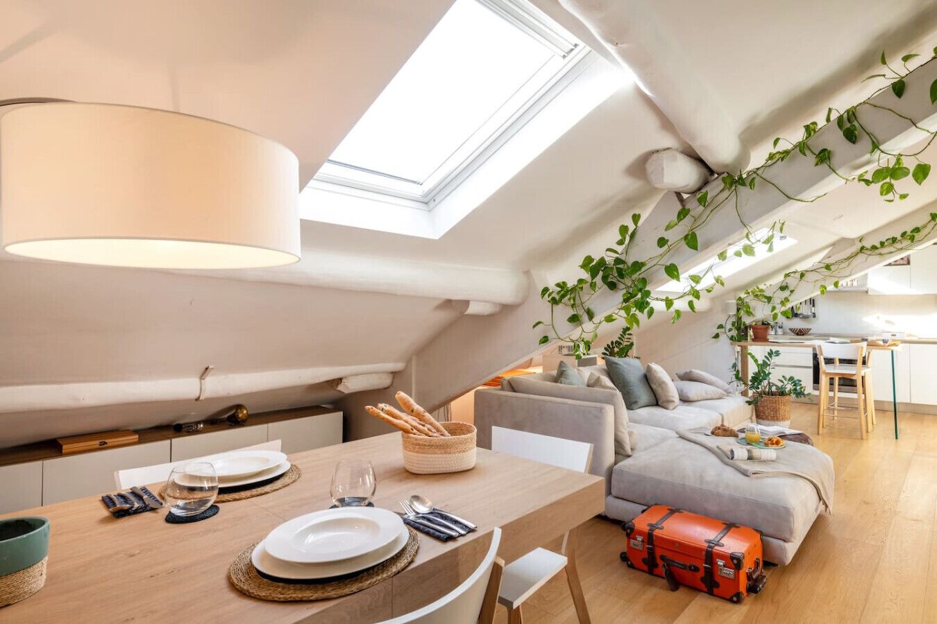 Un accogliente loft con zona pranzo, divano e cucina.