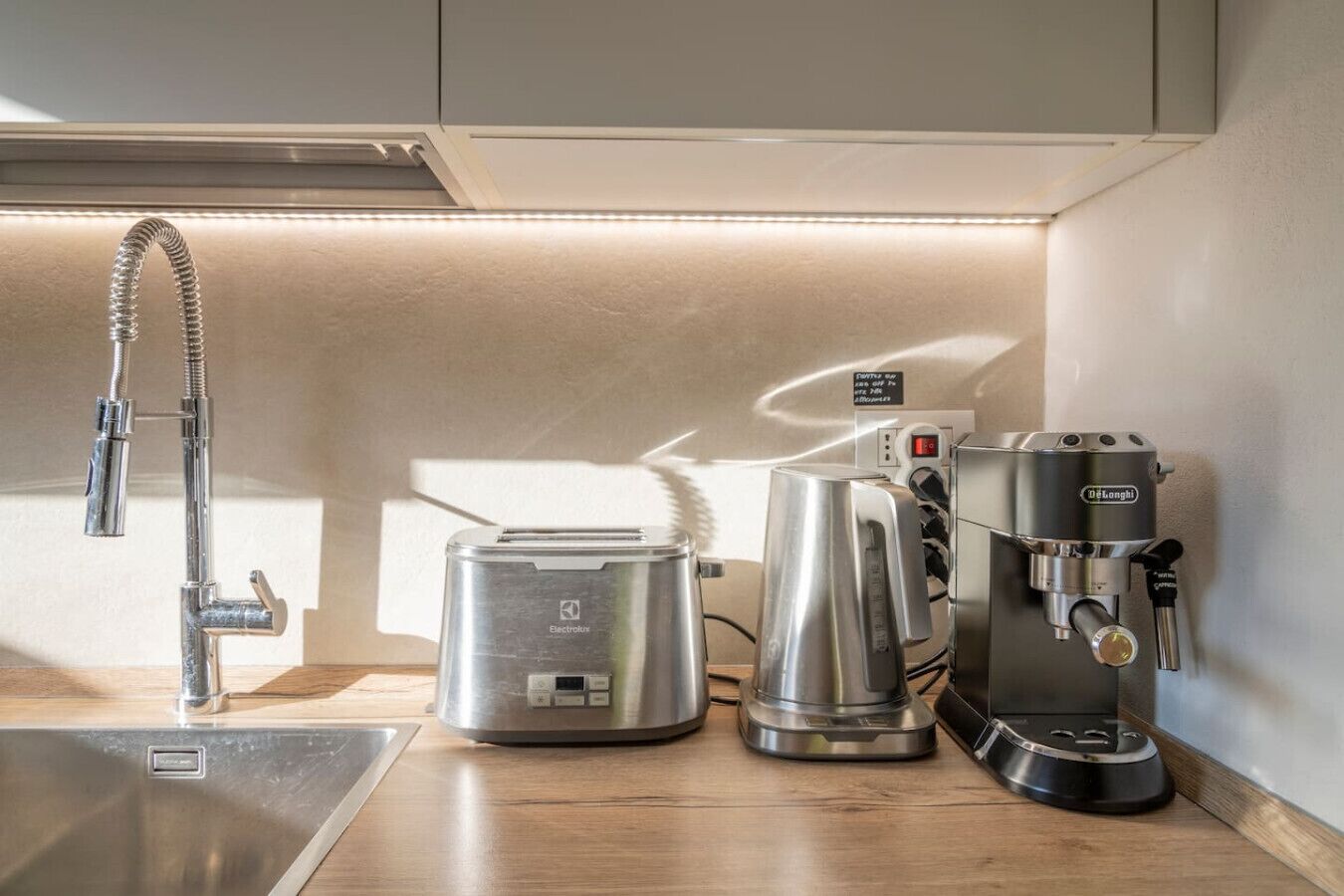Una cucina con una fontanella, una macchina per il caffè e un tostapane.