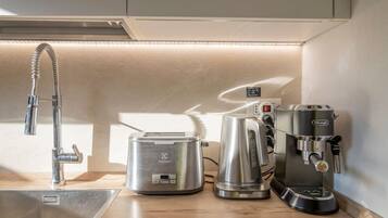 Una cucina con una fontanella, una macchina per il caffè e un tostapane.