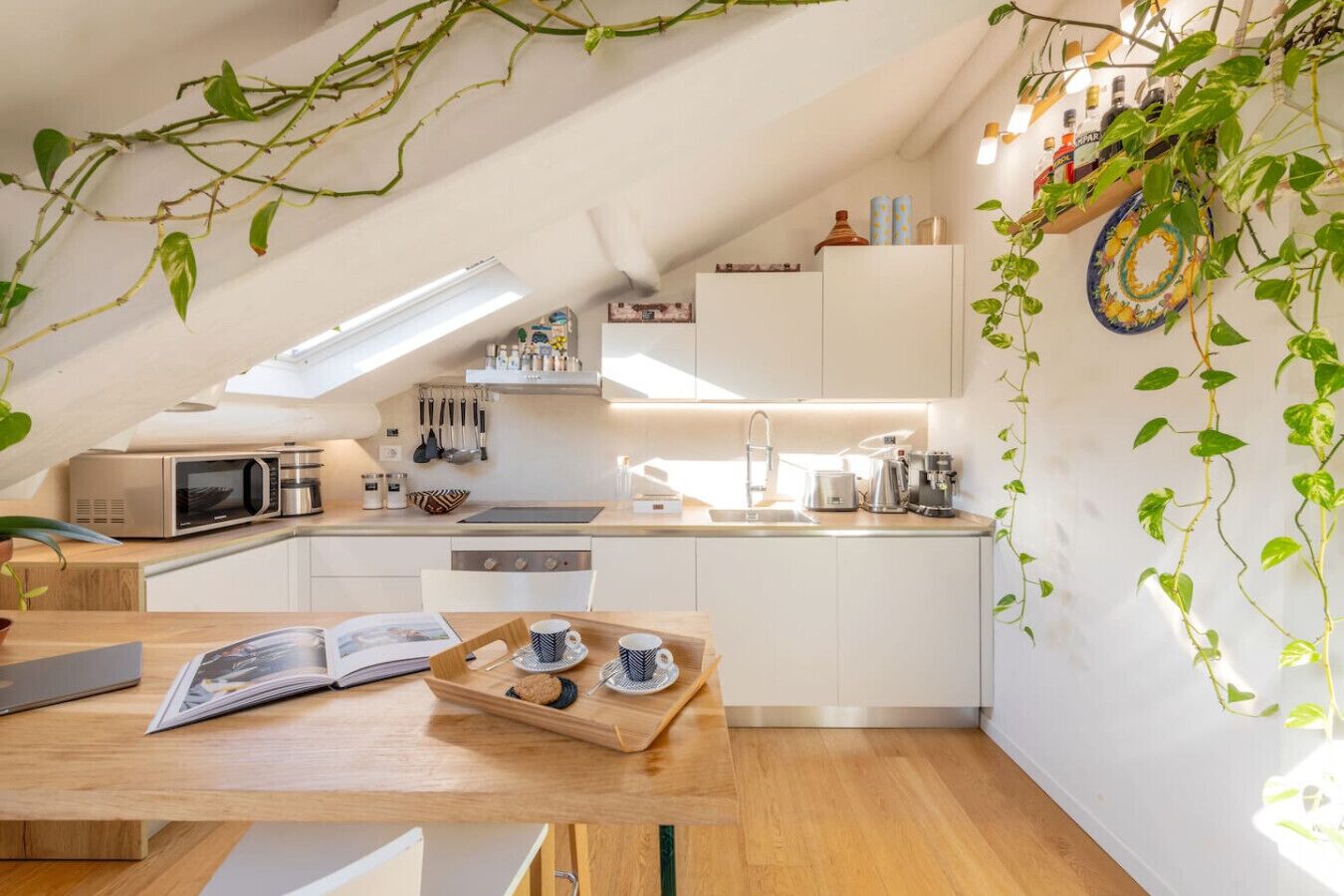 Eine moderne Küche mit weißen Schränken, einer Holz Arbeitsplatte und einem Oberlicht.