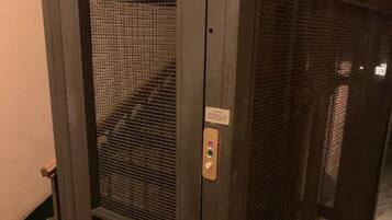 Une porte d’ascenseur en métal, dotée d’un clavier et d’une petite plaque au-dessus.