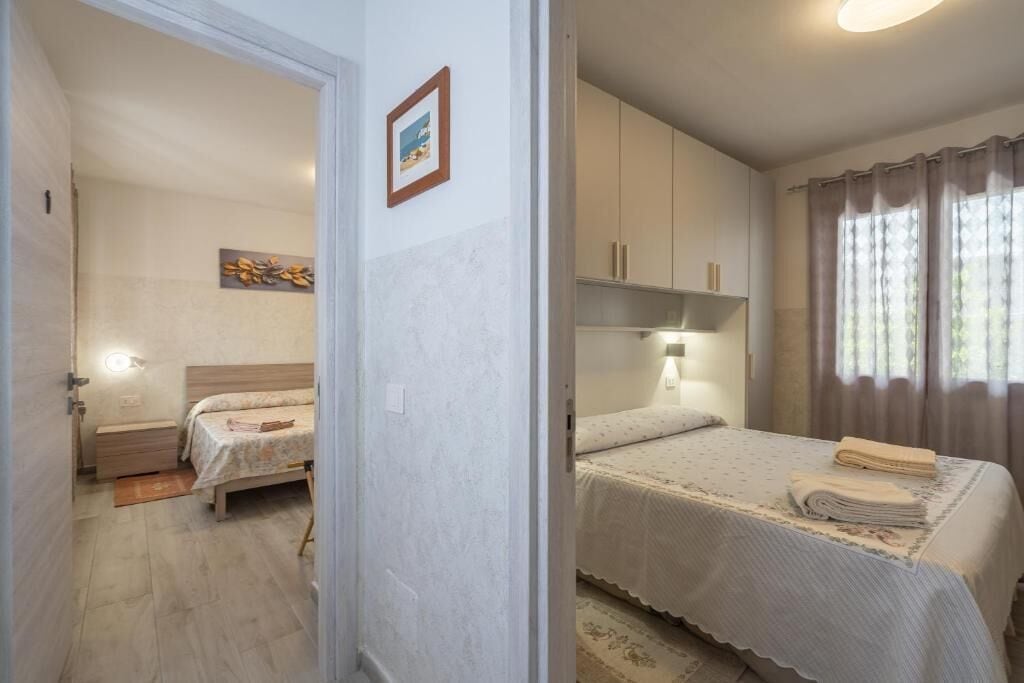 Una camera da letto con un letto, un comodino, una lampada e tende.