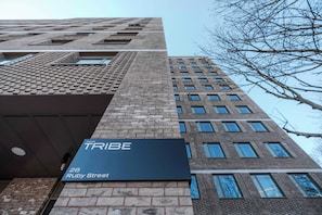 Ein Hochhaus mit einem Schild, das 'TRIBE 28 Ruby Street' anzeigt.