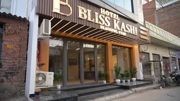 A hotel with a modern facade, large glass windows, and a sign that reads 'BLOSS KASHI HOTEL'.