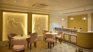Zona de recepción con mostrador, asientos y decoración en la pared.