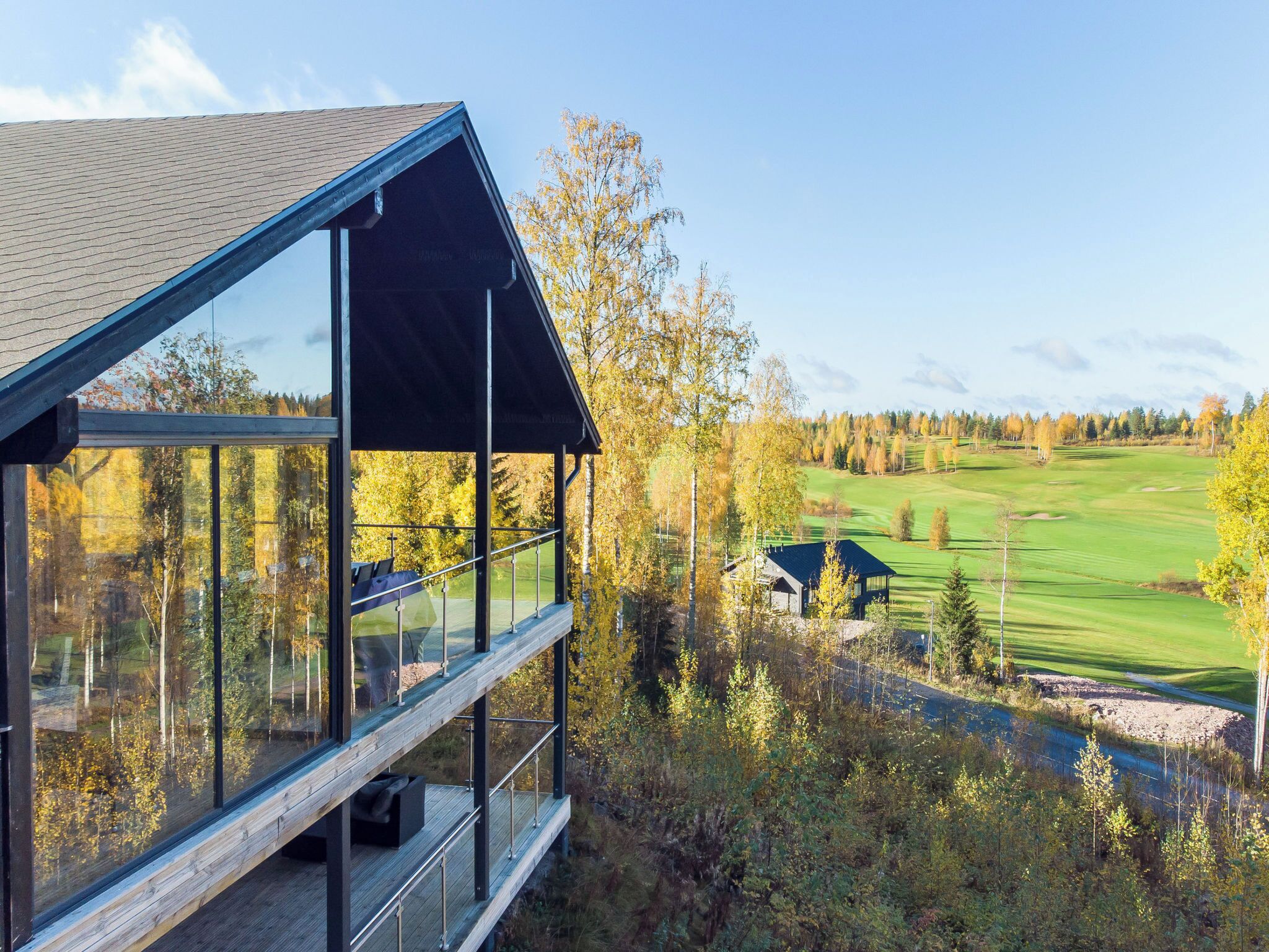 A modern building with large windows overlooking a golf course.