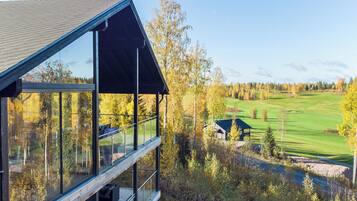 A modern building with large windows overlooking a golf course.