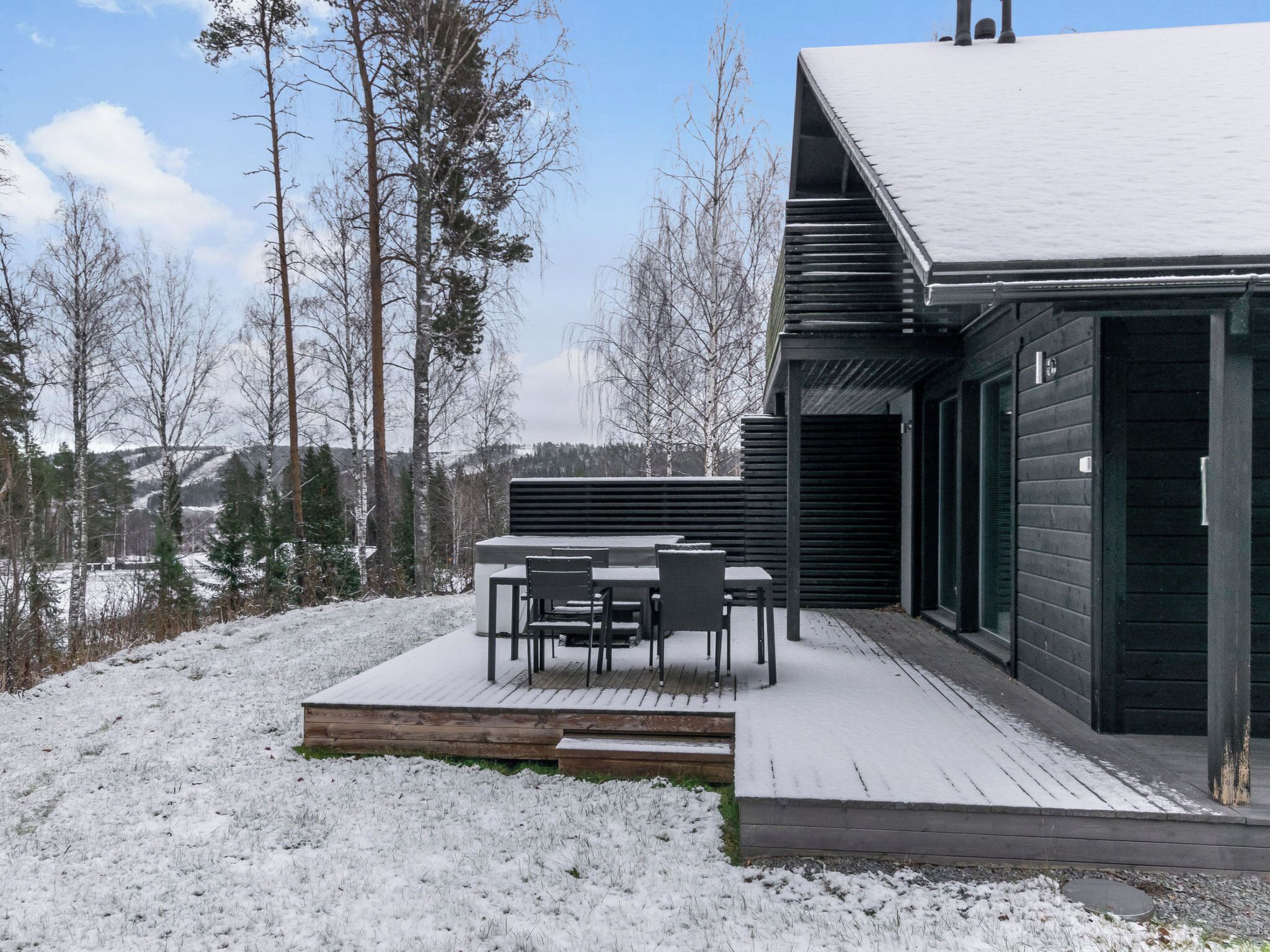 A modern building with a wooden deck and outdoor seating area.