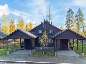 A modern building with three covered areas, a central entrance, and a small tree in the foreground.