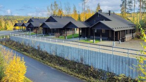 Une rangée de cabanes, avec une clôture en bois au premier plan.