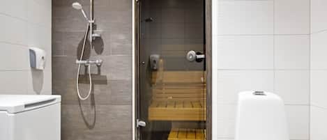 A modern bathroom with a shower, toilet, and a bench.