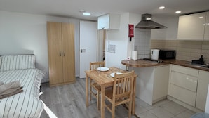 A compact living space with a kitchenette, a dining area, and a bed. - Cosy studio in Finsbury Park, 18 minutes from Central London (London)