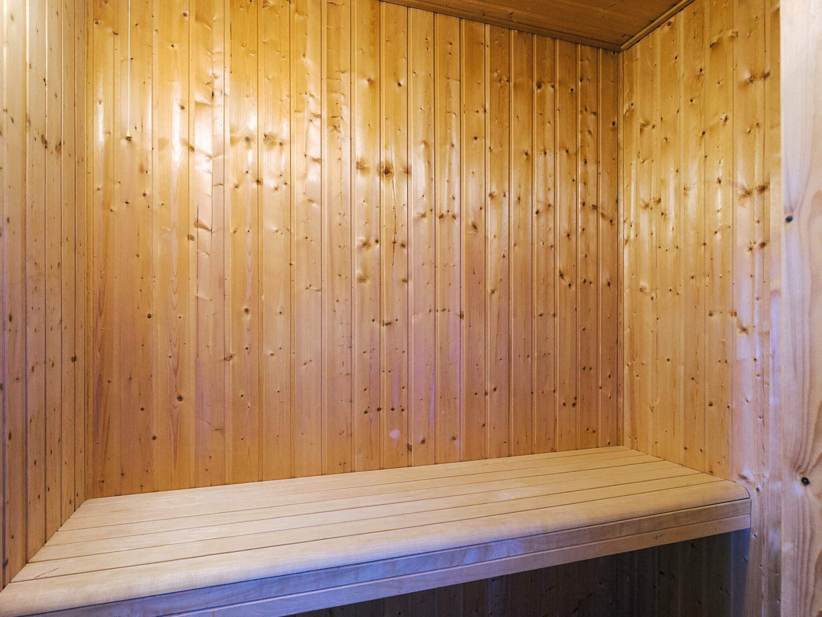 A wooden sauna with a bench.