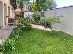 Ein gepflegter Garten mit verschiedenen Pflanzen und einem kleinen Baum.