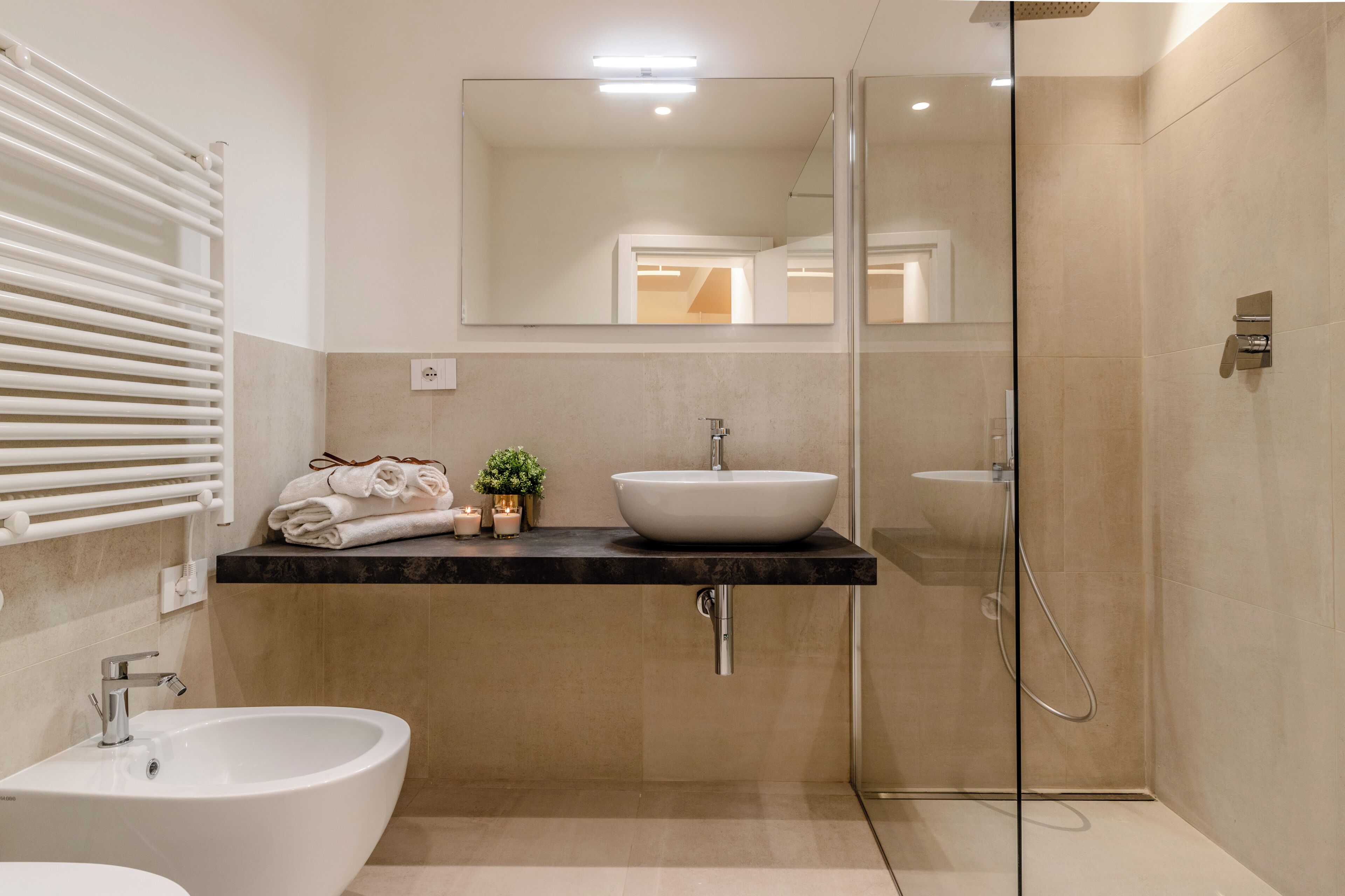 A modern bathroom with a freestanding bathtub, a sink with a vessel basin, and a glass-enclosed shower.