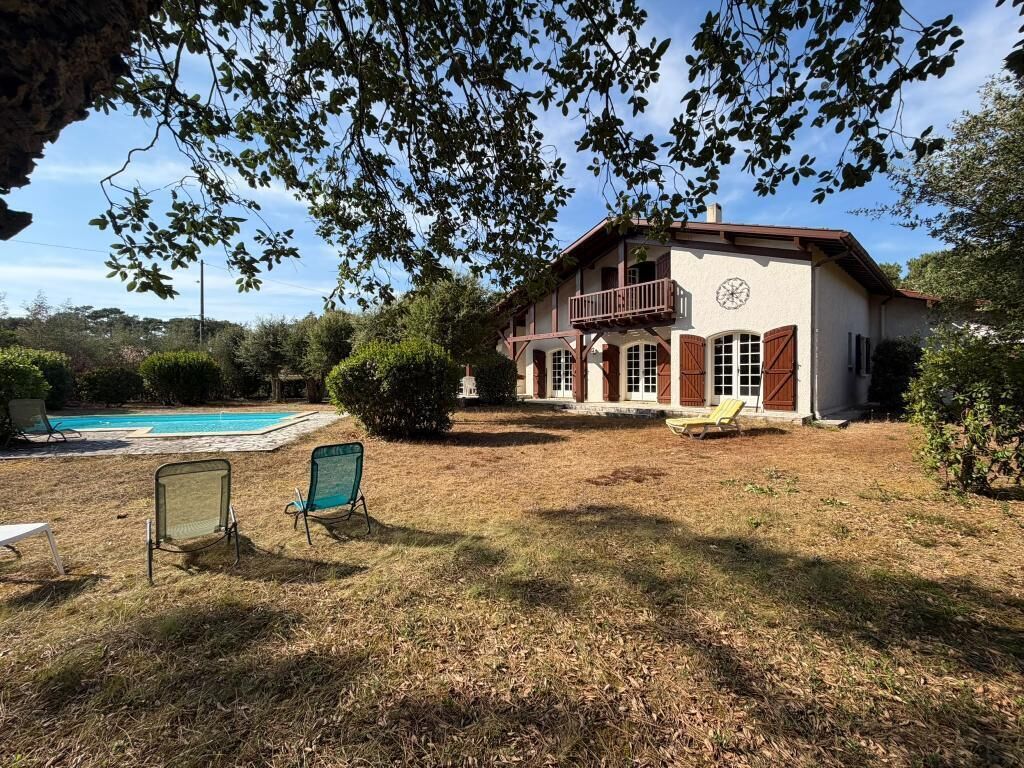 Une maison à deux étages avec une piscine, un balcon et une pelouse bien entretenue.