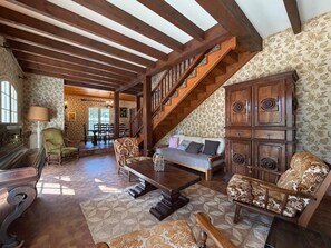A spacious living room with a high wooden ceiling, a staircase, and a patterned wall. - Etxe Océan - Swimming Pool (LABENNE OCÉAN)
