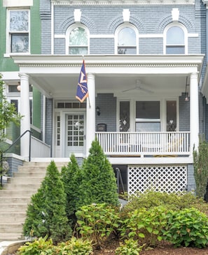 A two-story house with a porch, a flag, and a mailbox. - A stylish retreat in Mount Pleasant, one of DC's most walkable neighborhoods. Two bedrooms plus a sofa bed sleep six, with two full baths - plus the city's rarest luxury: your own private off-street parking. Walk to Metro, cafes & Zoo. (Washington)