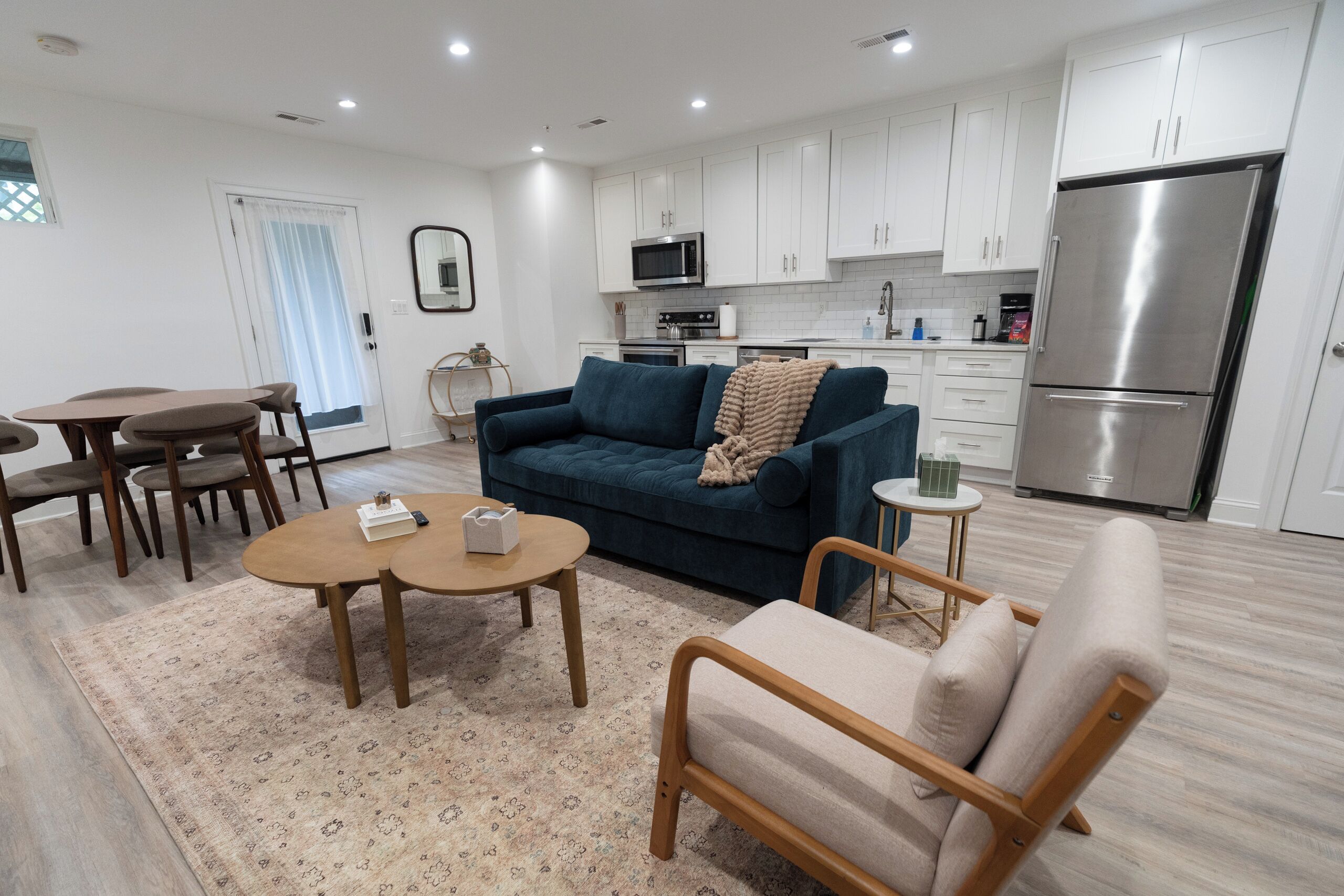 A modern living room with a sofa, coffee table, and dining area.