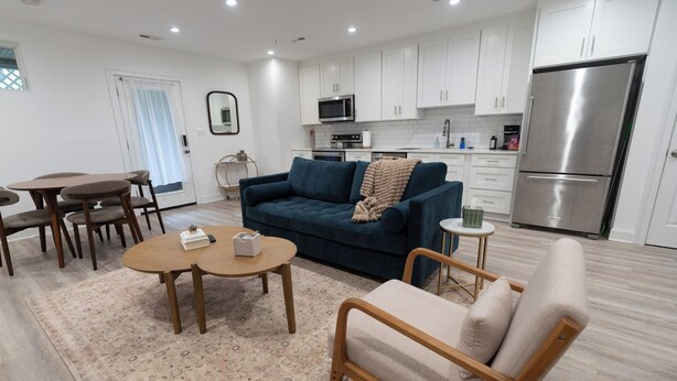 Ein modernes Wohnzimmer mit Sofa, Couchtisch und Essbereich.