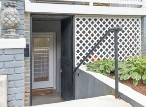 A residential entrance with a closed door, a white lattice fence, and a potted plant. - A stylish retreat in Mount Pleasant, one of DC's most walkable neighborhoods. Two bedrooms plus a sofa bed sleep six, with two full baths - plus the city's rarest luxury: your own private off-street parking. Walk to Metro, cafes & Zoo. (Washington)