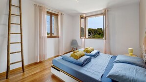 A bedroom with a bed, a ladder, a chair, and a window with a view. - Vacation home for 6 guests with private pool and garden. (Cagnes-sur-Mer)