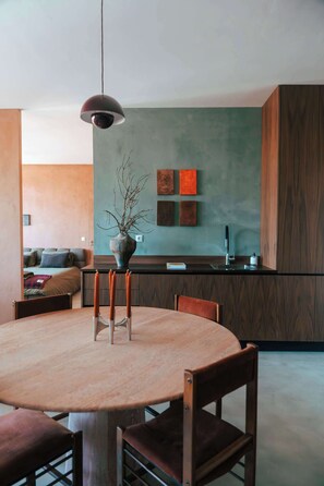 A modern kitchen with a dining area, a pendant light, and a vase with branches. - Stylish Boavista King Bed Studio - Casa da Musica (Porto)