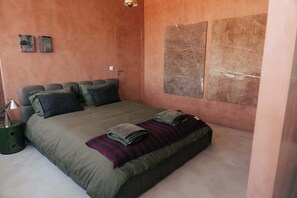 A bedroom with a bed, pillows, a blanket, a nightstand, and a wall with artwork. - Stylish Boavista King Bed Studio - Casa da Musica (Porto)