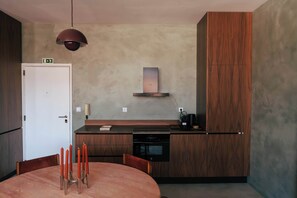 Una cocina moderna con horno empotrado, cafetera y un mueble de madera.