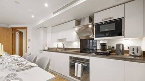 Uma cozinha moderna equipada com forno embutido, micro-ondas e máquina de café.