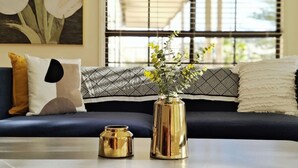 A living room with a sofa, a table, and a window with blinds. - Hunter Valley Nulkaba | breathtaking views & relax (Nulkaba)