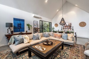 Ein modernes Wohnzimmer mit einem Ecksofa, einem Couchtisch und Kunstwerken an den Wänden.