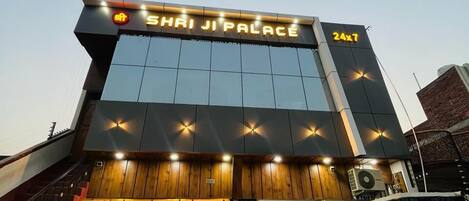 A hotel entrance with a sign reading 'Shri Ji Palace' and a 24x7 service indication.