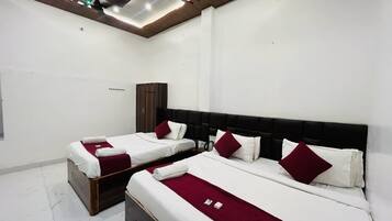 A hotel room with two beds, a wardrobe, and a ceiling light fixture.