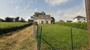 Een woonwijk met huizen, een grasveld en een heldere lucht.