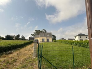 Ein Wohngebiet mit Häusern, einer grünen Wiese und blauem Himmel.