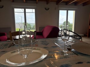 Ein Essbereich mit einem Tisch für zwei Personen, Stühlen und Blick durch ein Fenster.