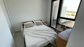 A bedroom with a bed, a chair, a window, and a radiator. - Luxury 3-bedroom apartment with panoramic views. (Calpe)