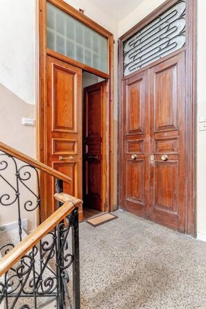 A wooden door with a glass panel and a metal decorative element above it. - The Mazzini Residence (Cosenza)